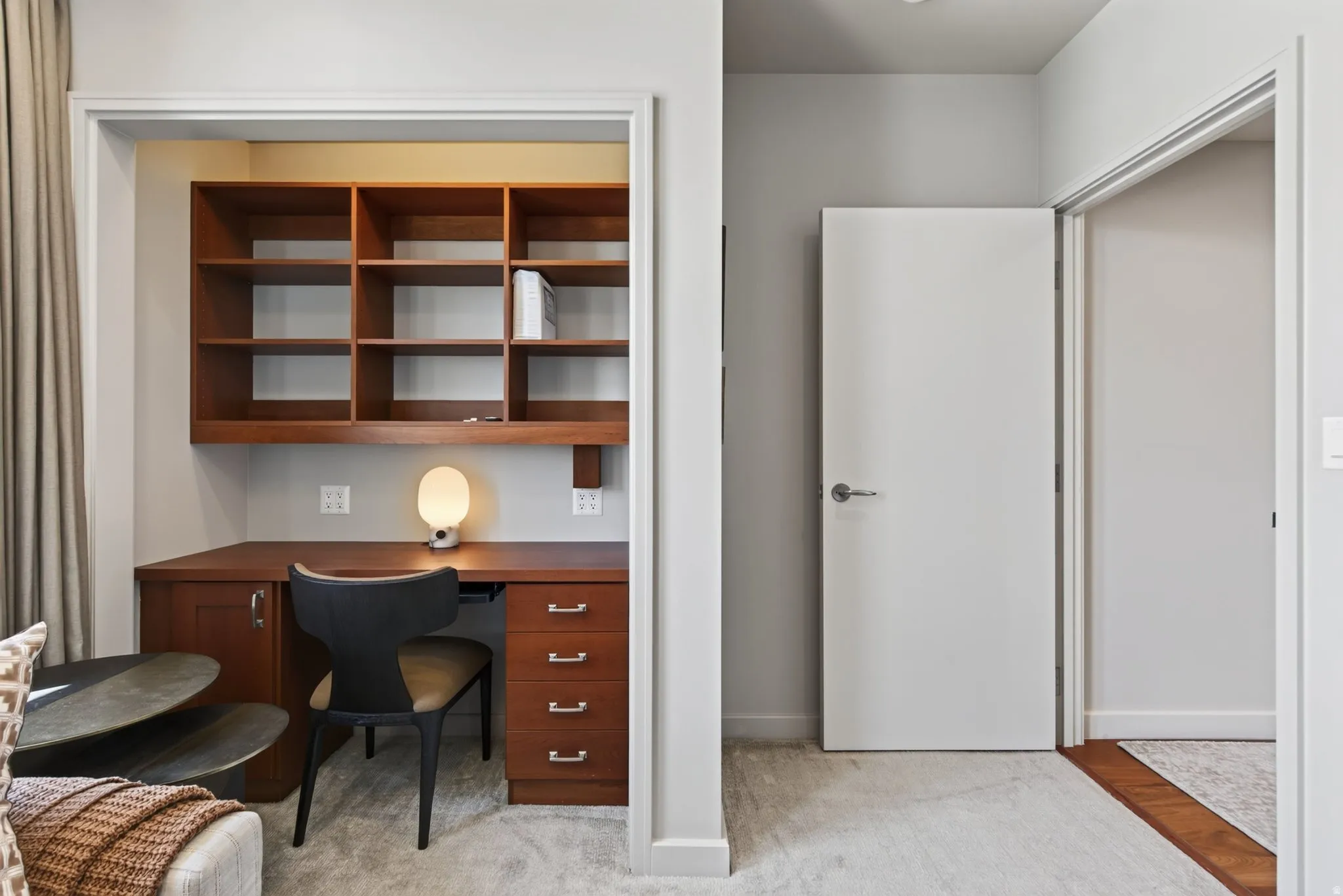 Integrated workstation featuring wood-finish shelving and desk, built-in drawers, and a dedicated alcove