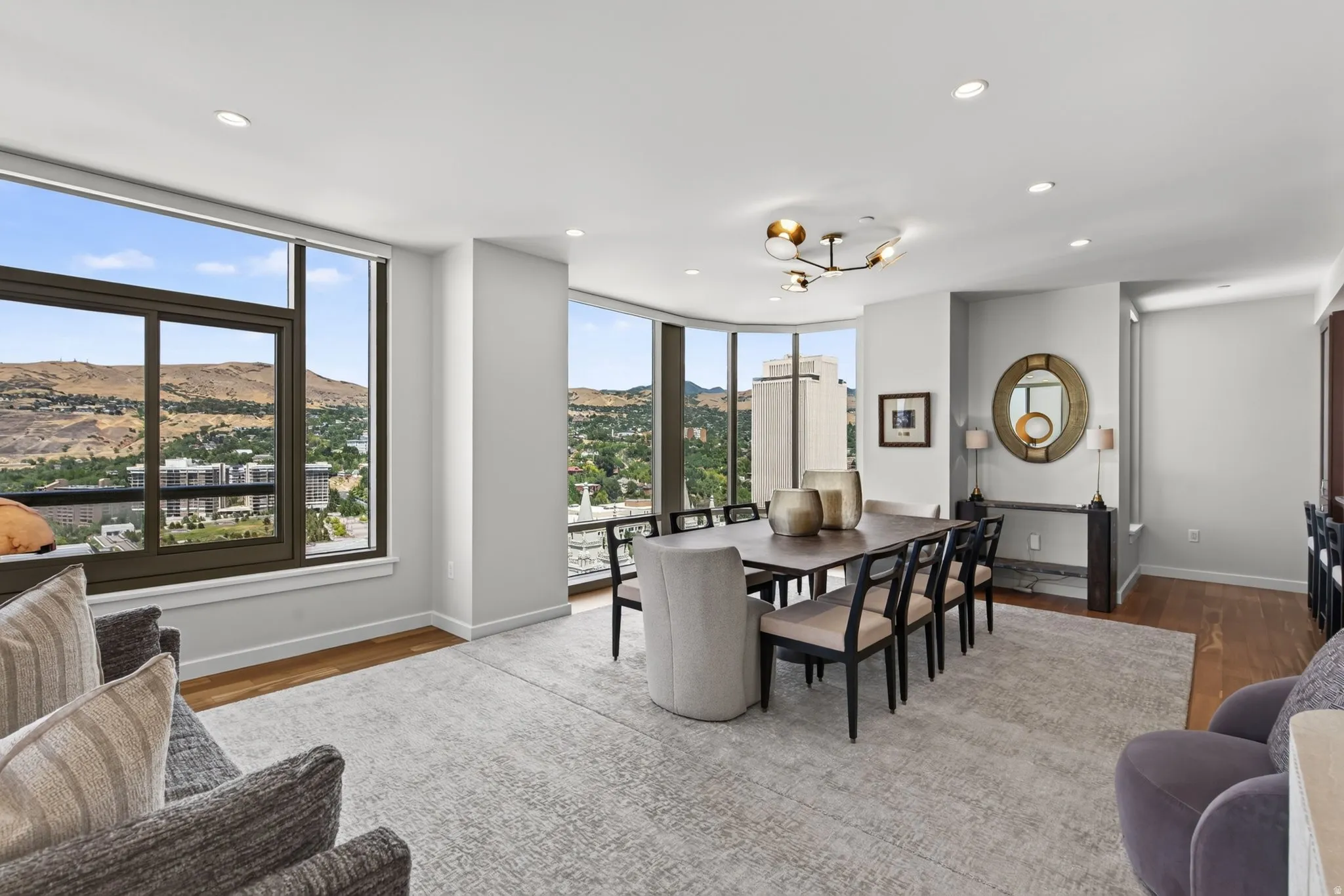 Spacious dining area featuring expansive windows, recessed lighting, wood-finish flooring, and a modern chandelier
