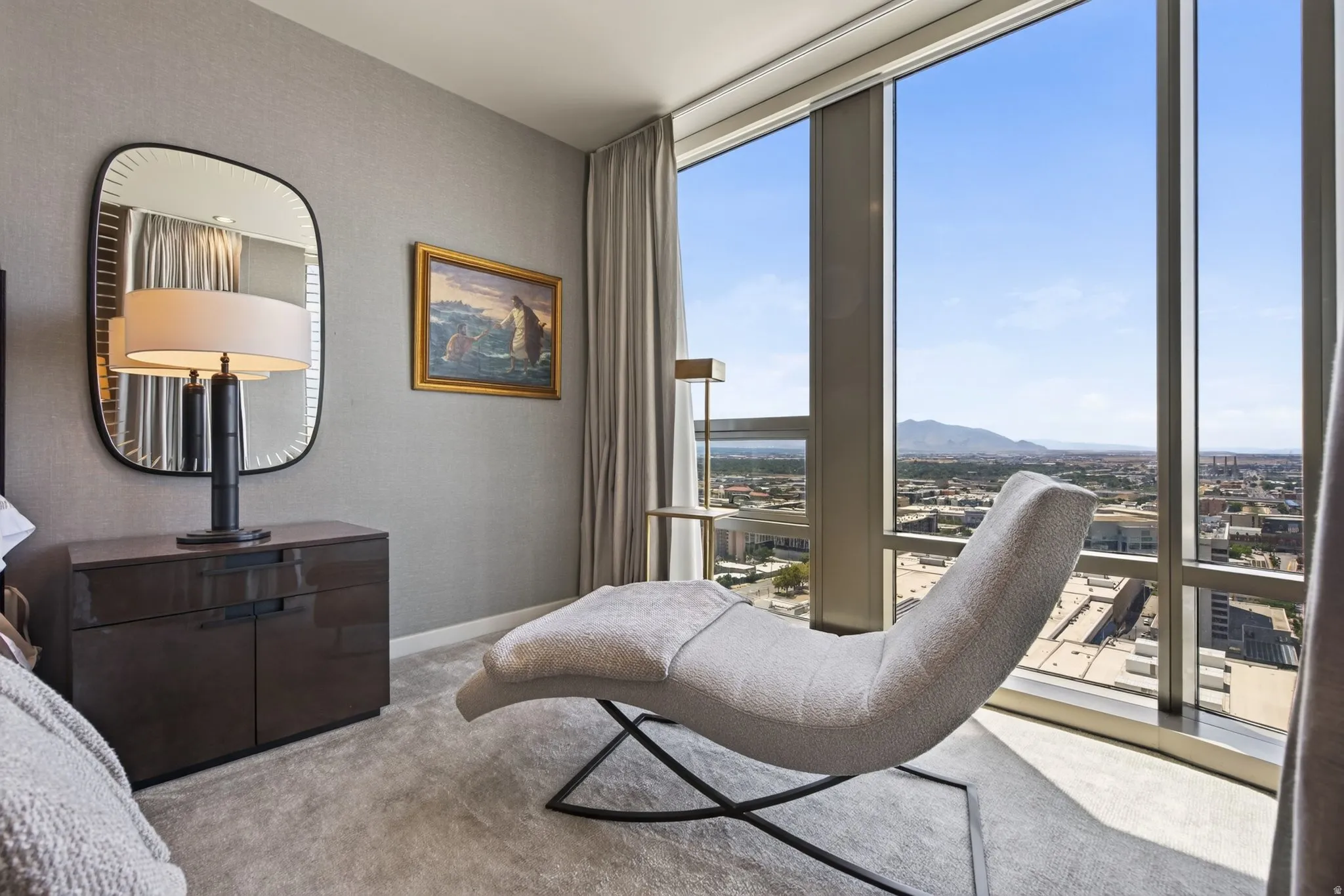 Floor-to-ceiling windows with expansive city and mountain scenery