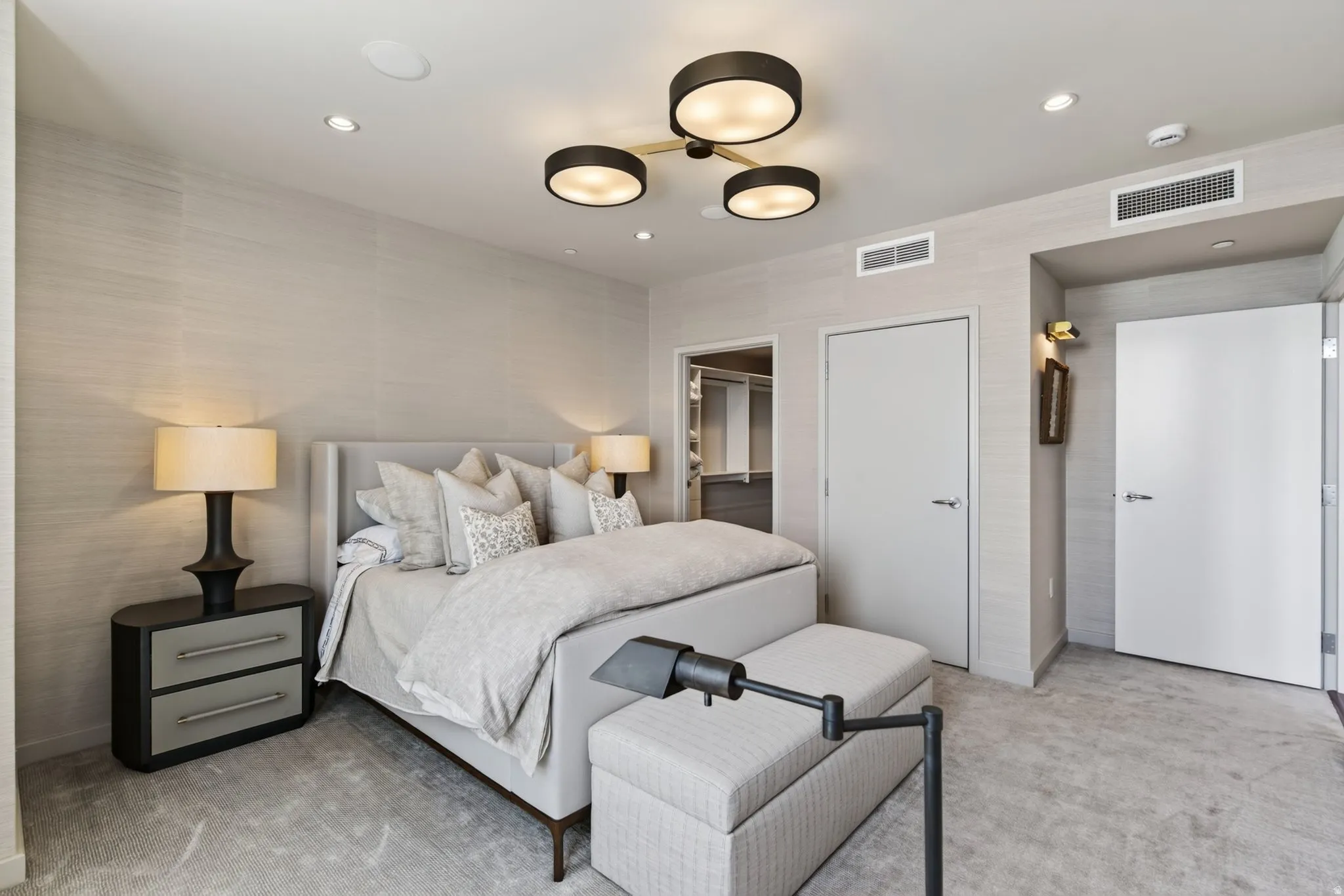 Neutral-toned bedroom featuring recessed lighting and a central contemporary chandelier