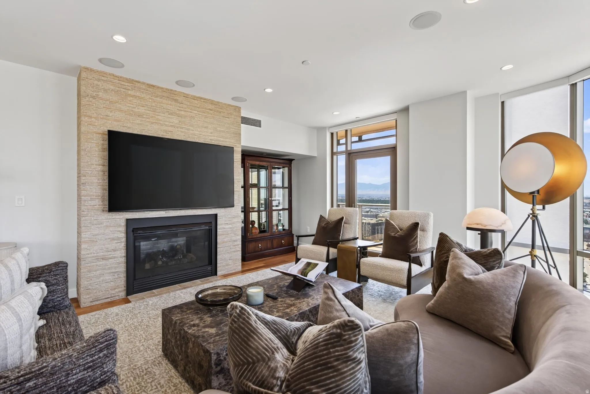 Living area with a textured stone-clad fireplace and wall-mounted television