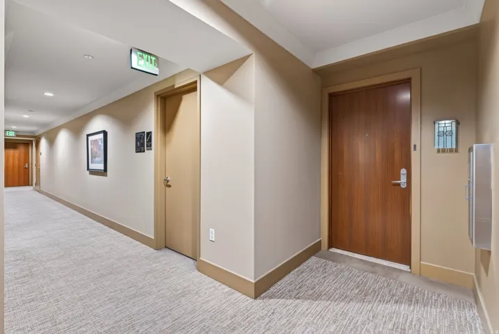 Building corridor featuring recessed lighting and wall sconces