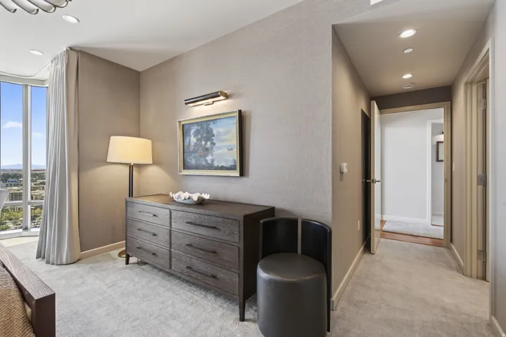 Wall-to-wall carpeting throughout this space with a full-height window featuring vertical drapes