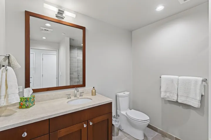 Bathroom vanity featuring a wood-framed mirror, undermount sink, and polished chrome fixtures