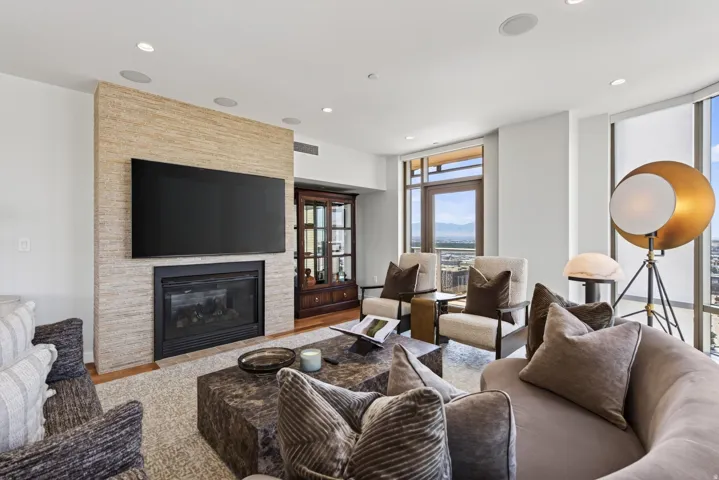 Living area with a textured stone-clad fireplace and wall-mounted television