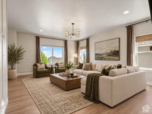 Spacious living area featuring wood-finish flooring, recessed lighting, and a chandelier