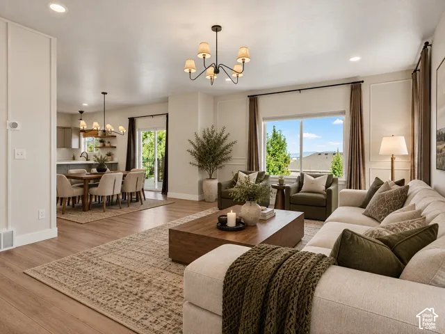 Spacious living area with wood-finish flooring, recessed lighting, and decorative wall molding