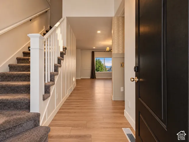 Hardwood-style flooring extends through the entryway with board and batten wall detailing