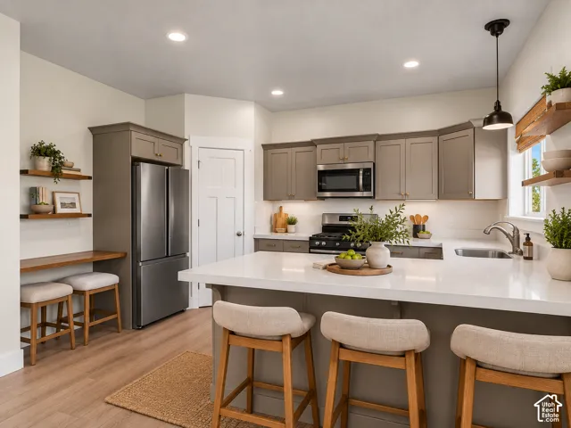 Kitchen featuring a central island with white countertop, recessed lighting, wood-finish flooring, and gray cabinetry
