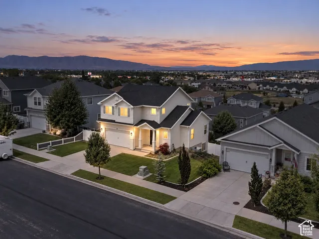 Contemporary two-story residence with a two-car garage, manicured front lawn, and mature landscaping