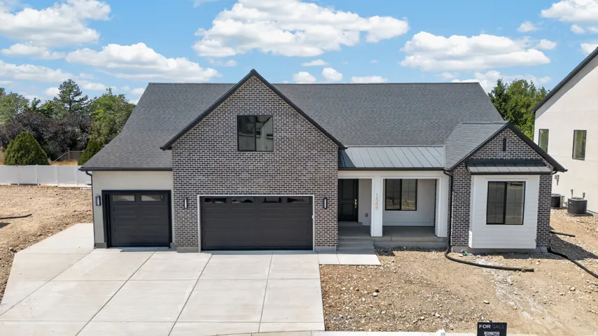 Contemporary brick and siding exterior with a covered entry, multiple gables, and an attached two-car garage