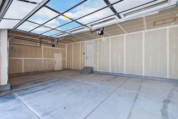 Concrete flooring, two interior access doors, automatic garage door opener, overhead lighting