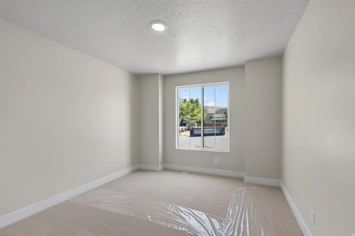 Recessed lighting, neutral paint palette, carpeting, picture window, and white trim