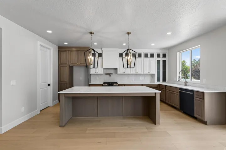 Kitchen featuring a substantial island with countertop, light wood-finish flooring, recessed lighting, and a window with outdoor scenery