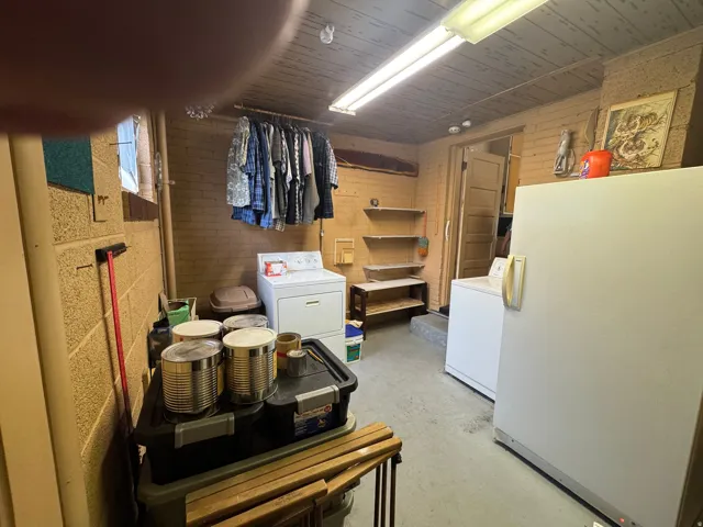 Utility space featuring a washer, dryer, and an additional freestanding refrigerator
