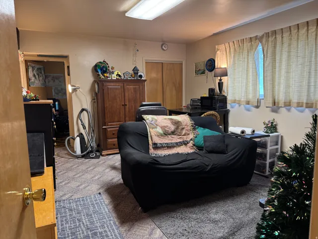 Carpeted room with recessed lighting and a window featuring textile window treatments