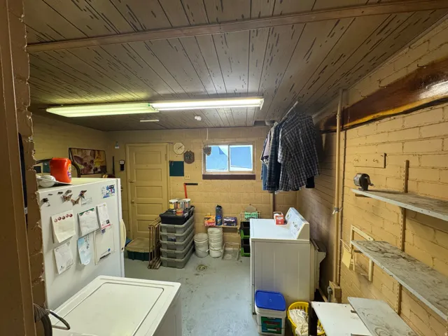 Utility room featuring a washer and dryer, exposed brick walls, and a wood-finish plank ceiling