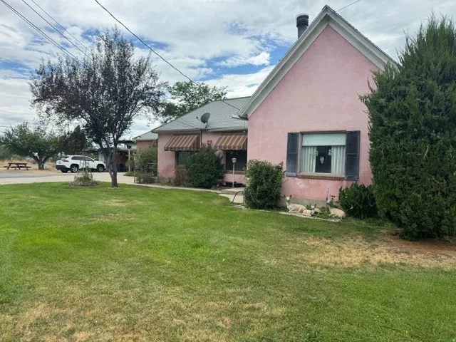 Pink stucco exterior with dark window shutters and a gabled roofline