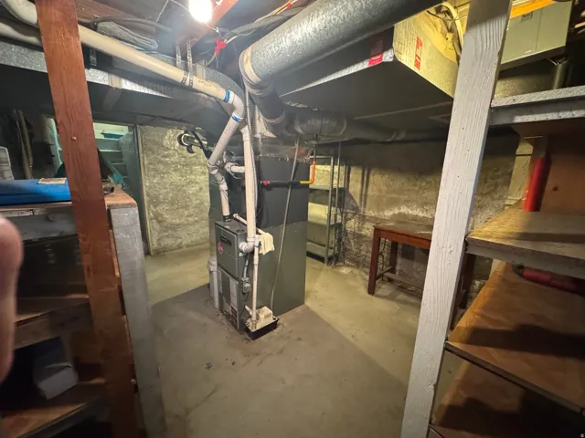 Basement utility area featuring a furnace unit and extensive overhead ductwork