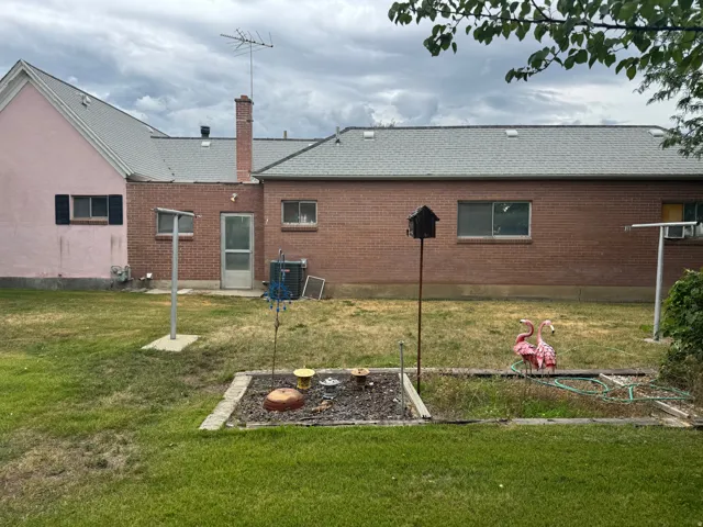 Rear exterior featuring a brick facade with a contrasting pink stucco section
