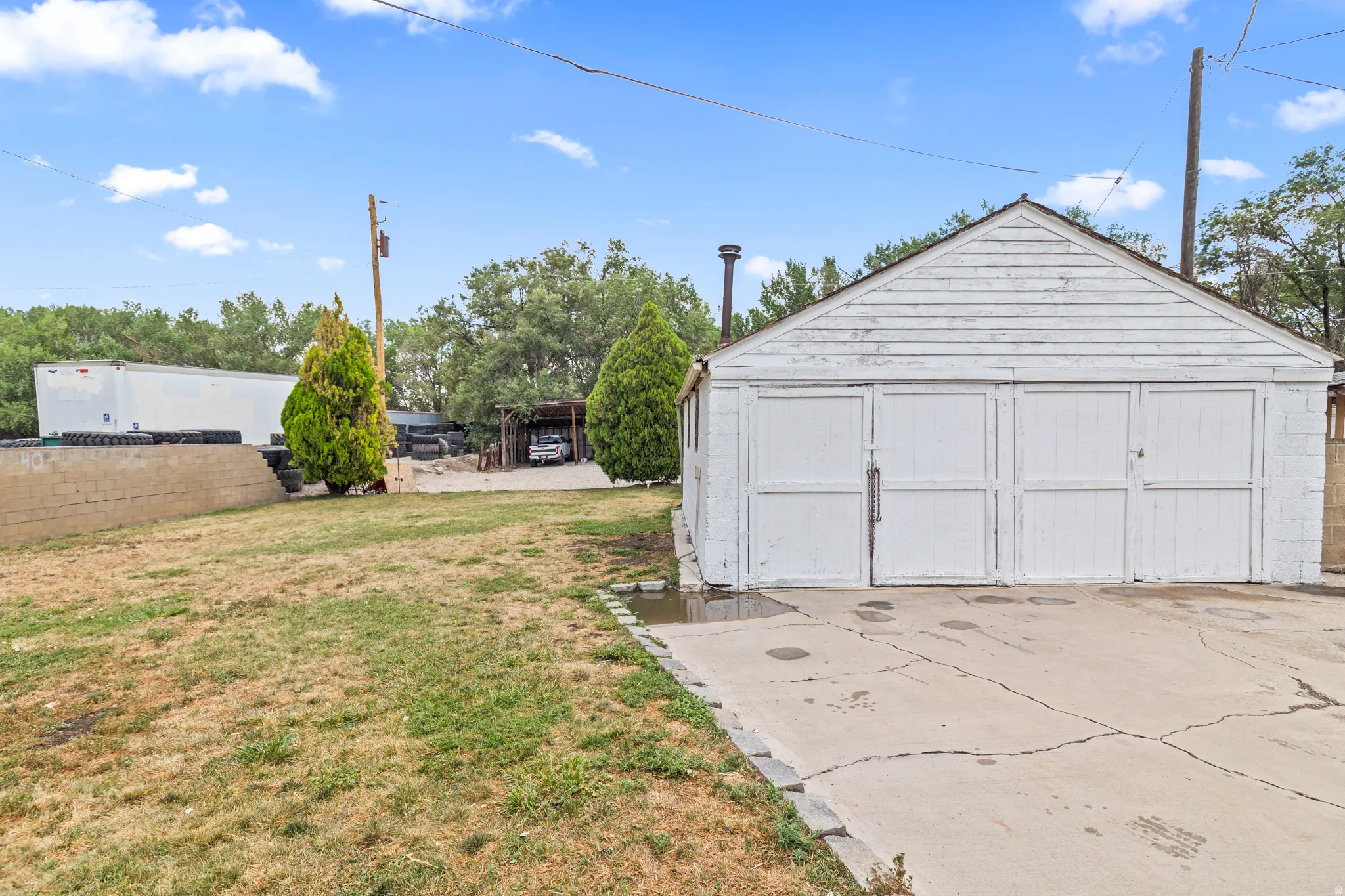 Detached garage structure with white siding and three garage bays
