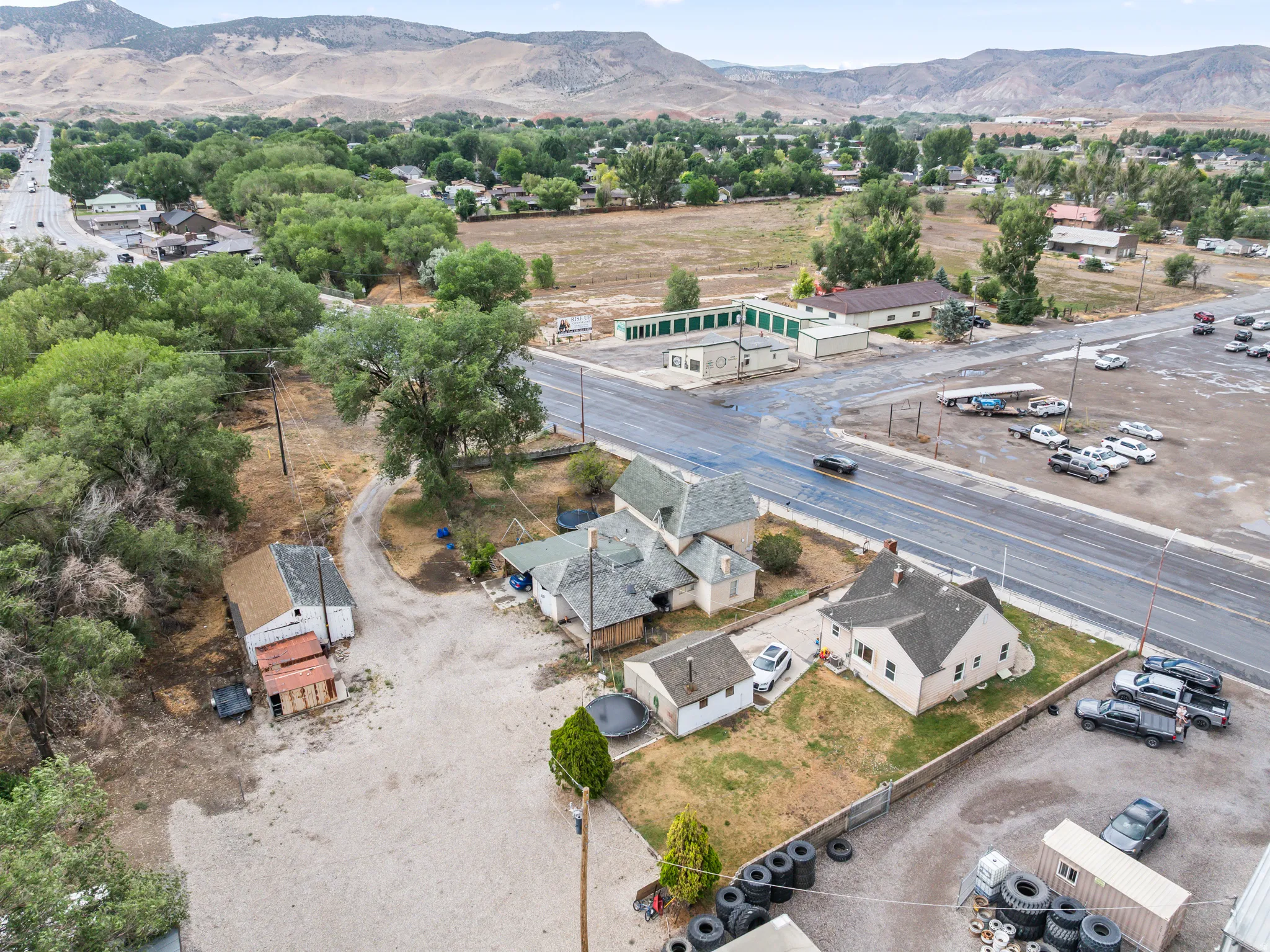 Aerial perspective showcasing a residential property with multiple structures and a gravel lot