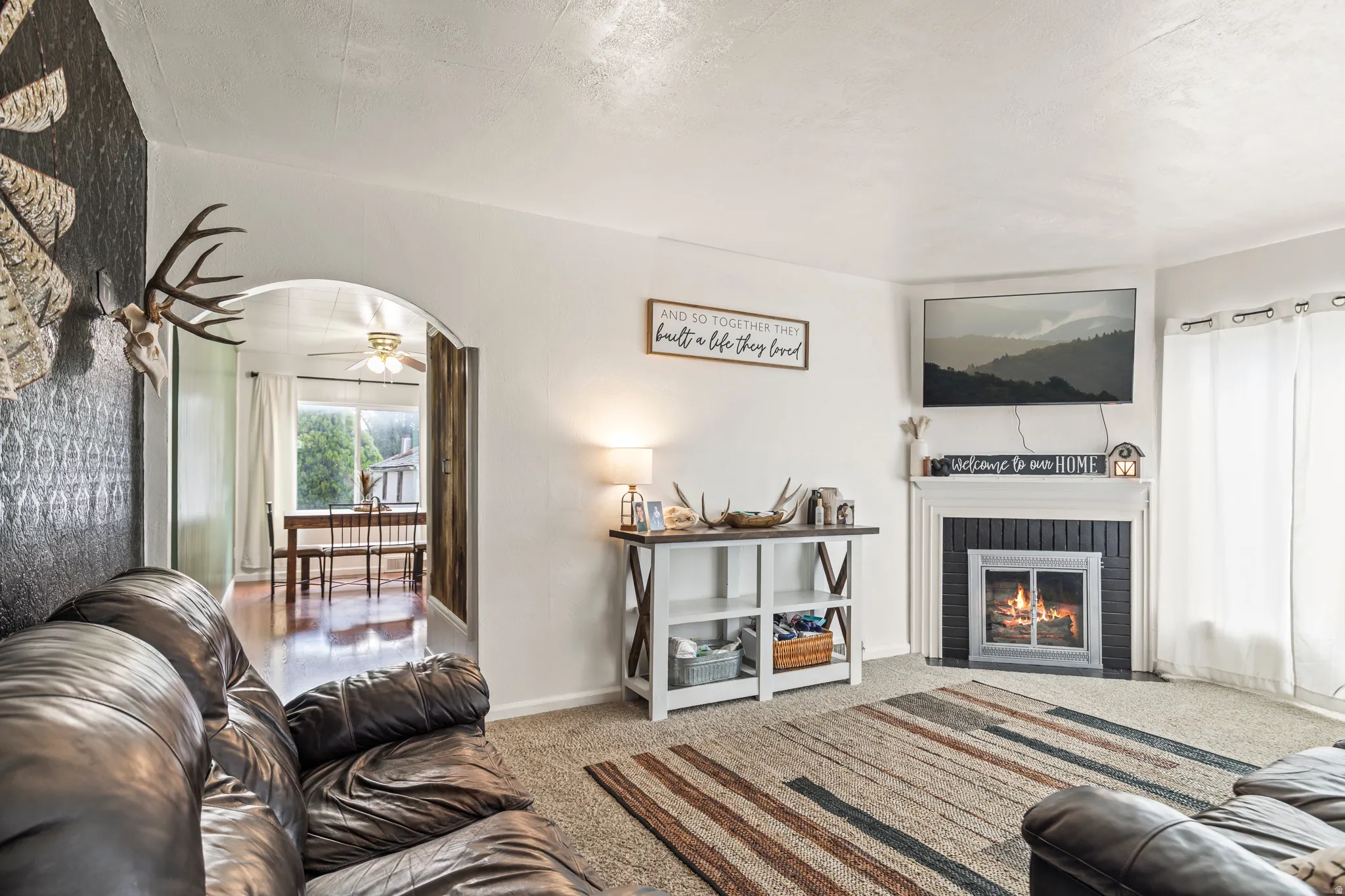 Living area with a fireplace featuring a white mantel and black surround