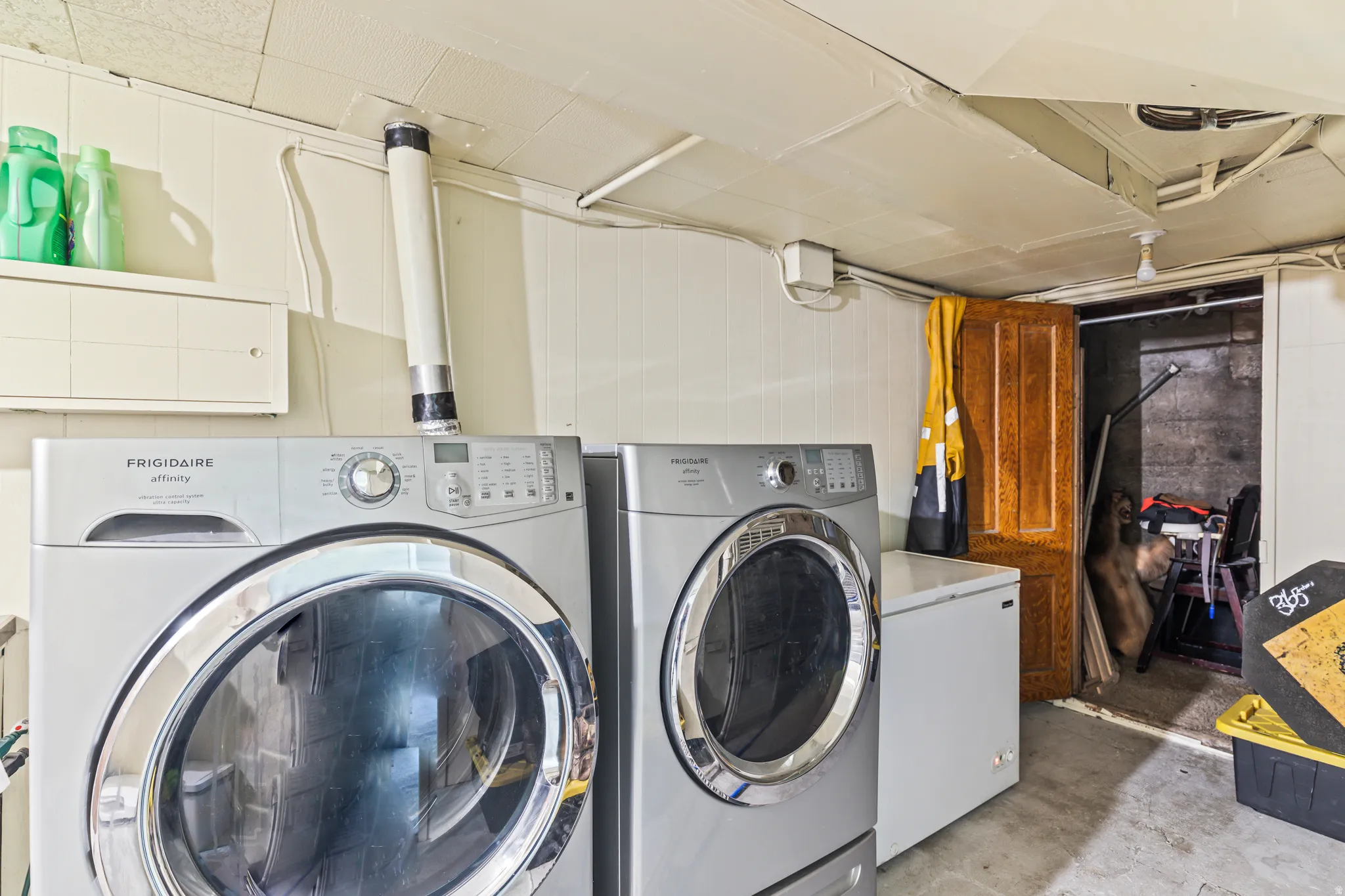 Laundry area featuring painted paneled walls and a drop ceiling