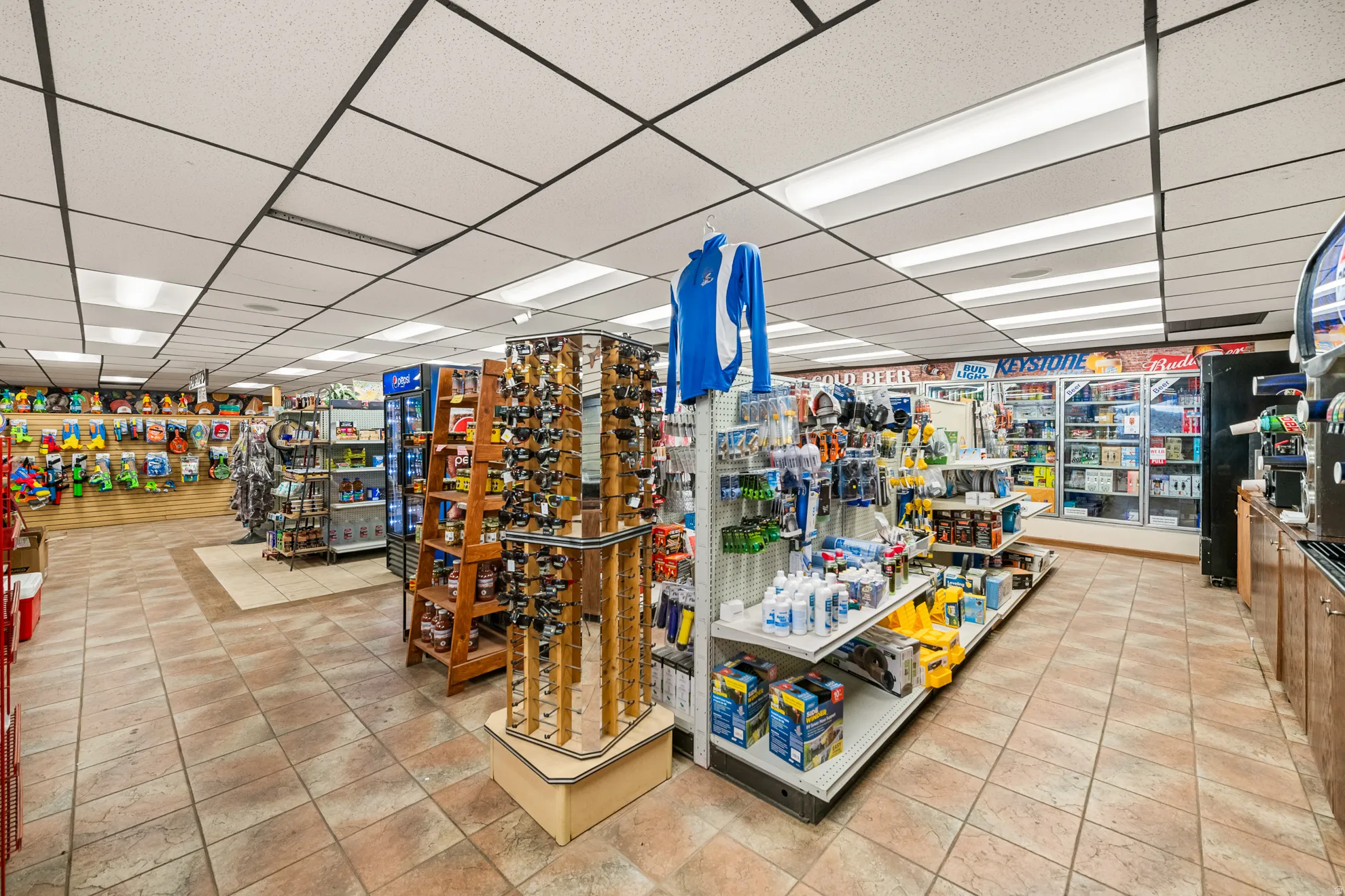 Retail interior featuring tiled flooring and a drop ceiling with integrated lighting