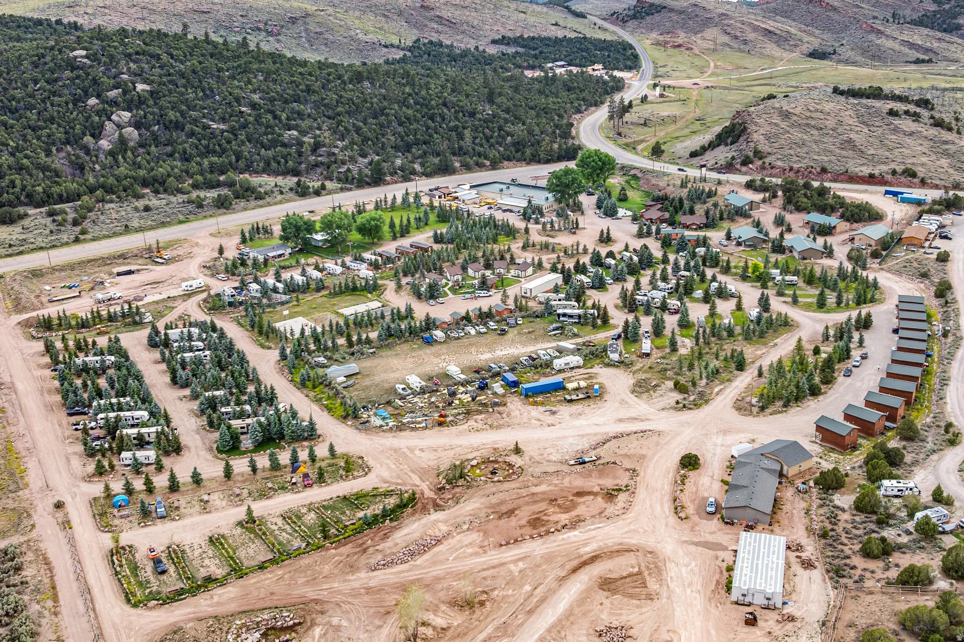 Expansive property featuring multiple structures, RV parking, and mature trees