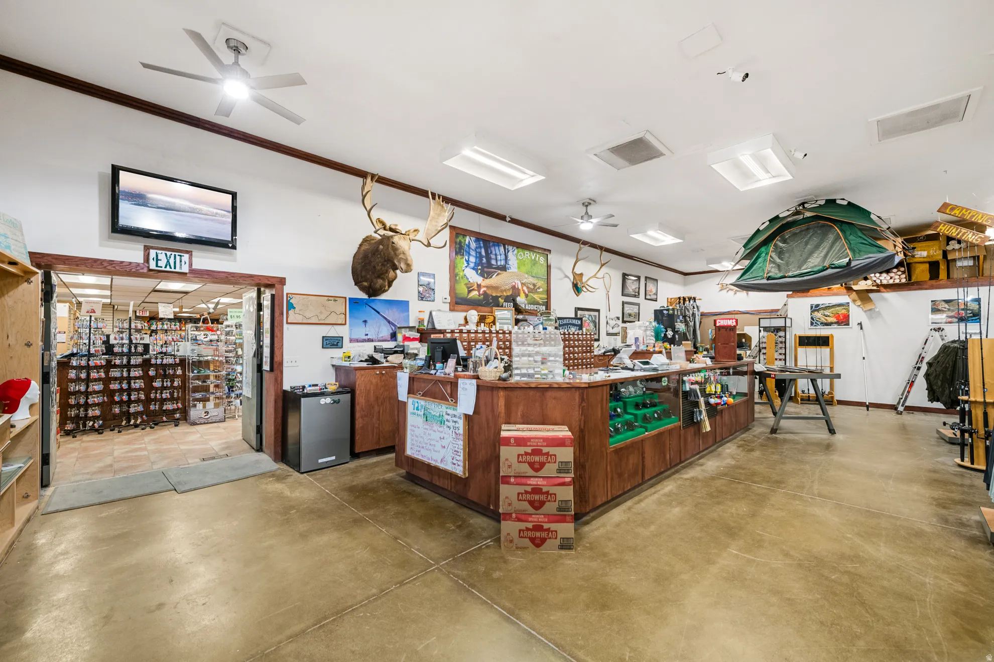 Retail space featuring concrete flooring, multiple ceiling fans, recessed lighting, and wooden display counters