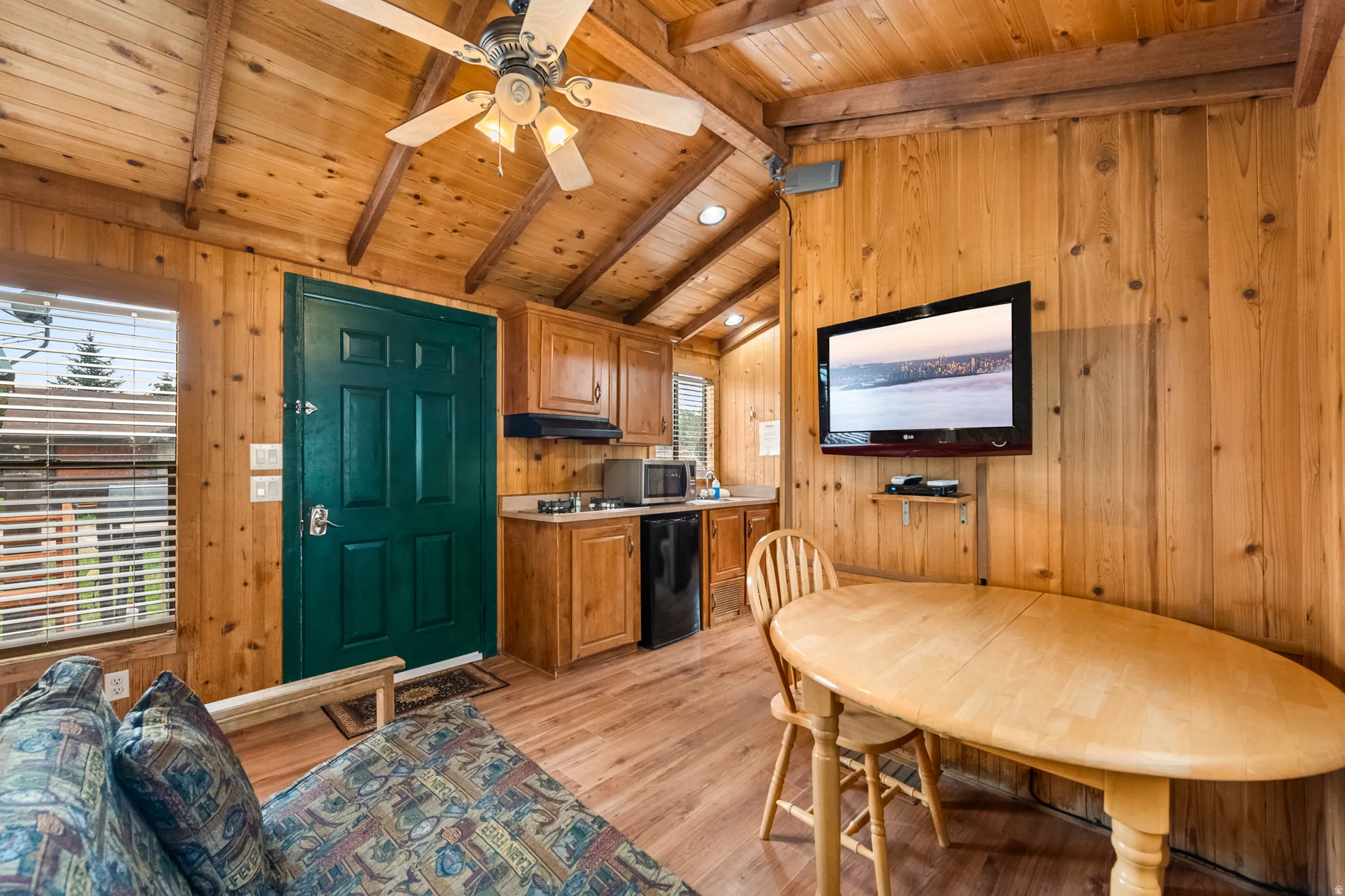 Vaulted wood-paneled ceilings with exposed beams and a ceiling fan