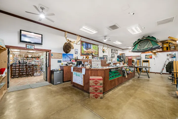 Retail space featuring concrete flooring, multiple ceiling fans, recessed lighting, and wooden display counters