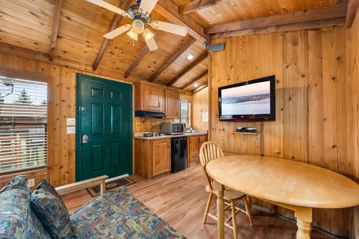 Vaulted wood-paneled ceilings with exposed beams and a ceiling fan