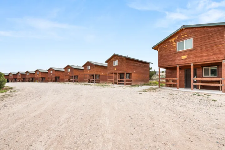 Multiple rustic cabins featuring wood siding and individual covered porches with railings