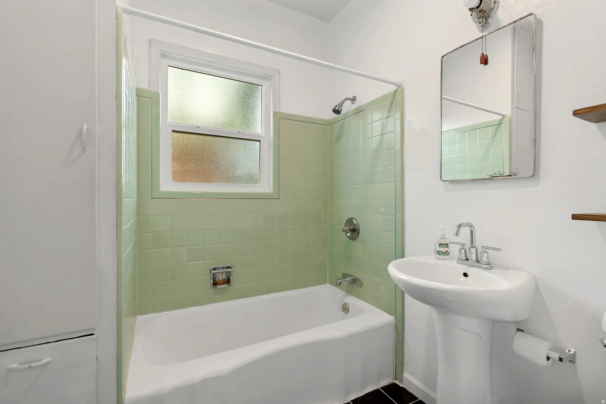 Bathroom featuring a white pedestal sink, chrome faucet, and mirrored medicine cabinet