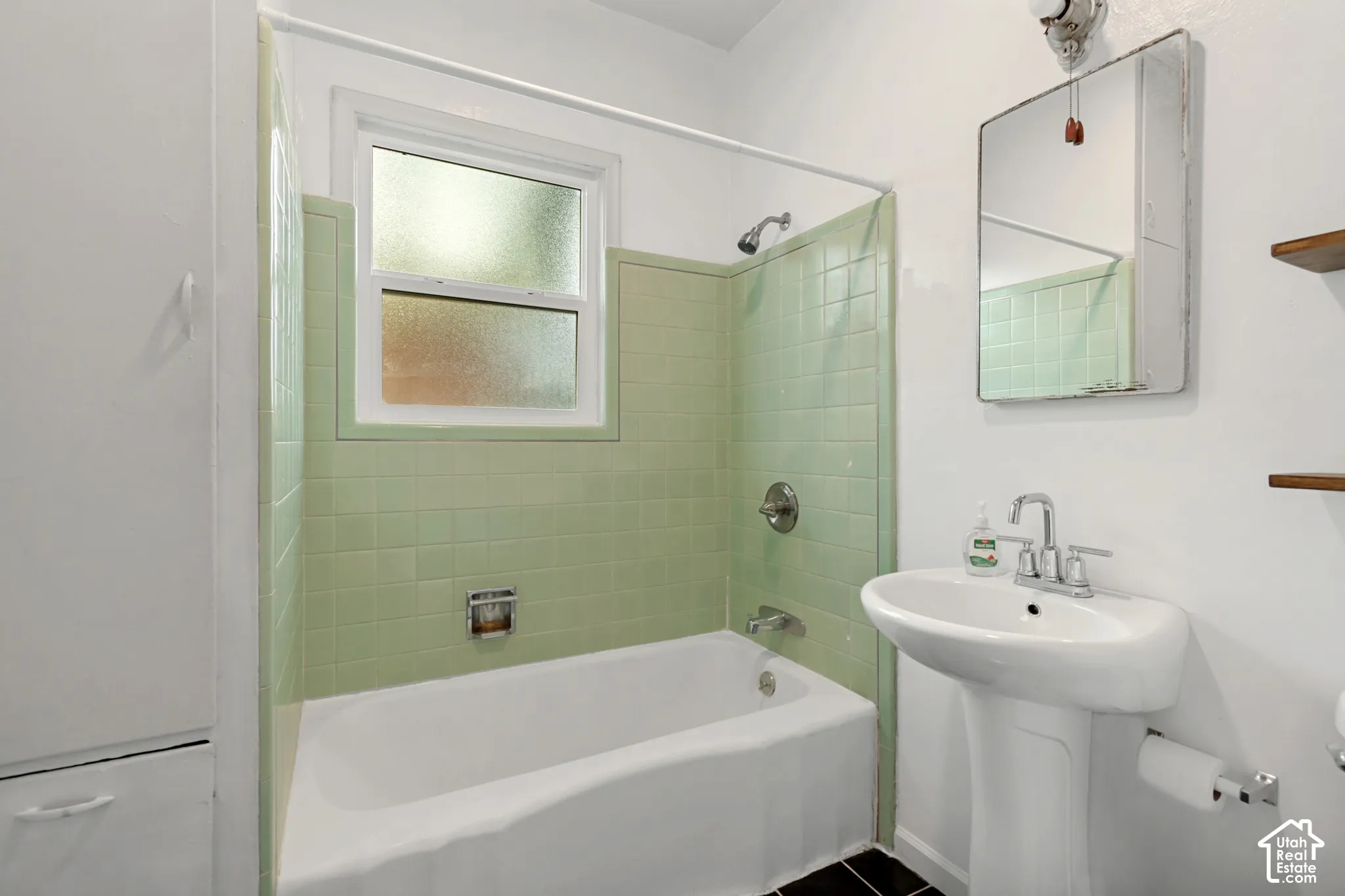 Bathroom featuring a white pedestal sink, chrome faucet, and mirrored medicine cabinet