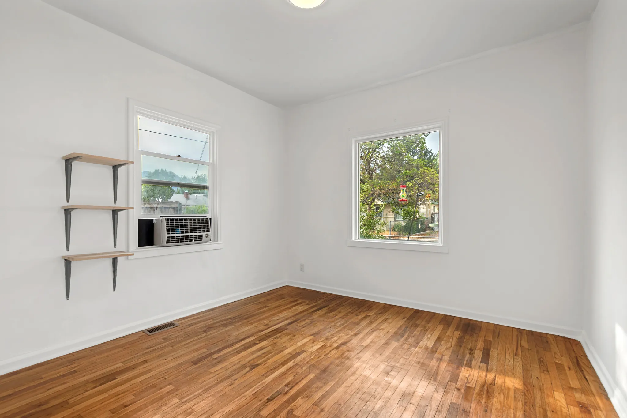 Bright interior space featuring wood-finish flooring, white walls, and a recessed ceiling light