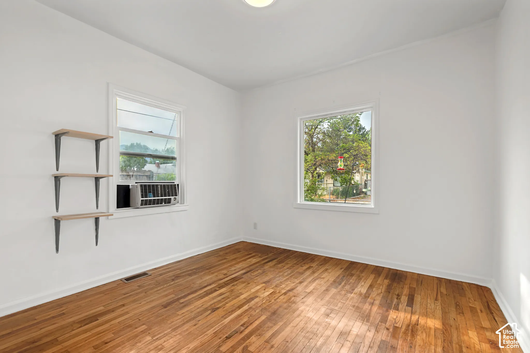 Bright interior space featuring wood-finish flooring, white walls, and a recessed ceiling light