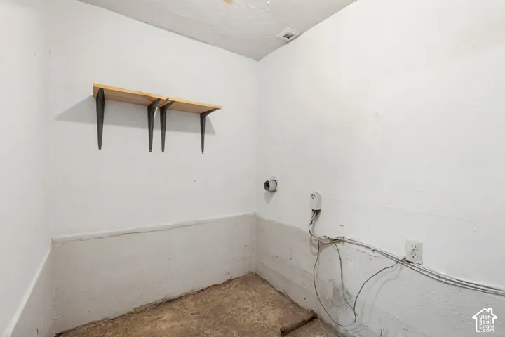 Utility room featuring white painted walls and concrete flooring