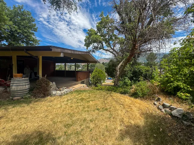 Covered patio with concrete flooring, supported by columns, and featuring an exterior railing