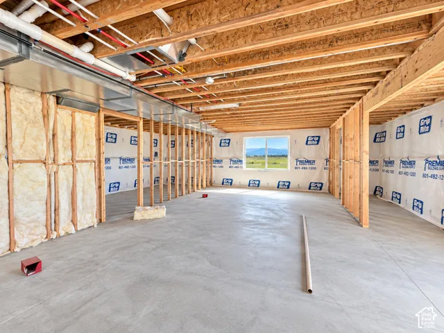 Unfinished basement with concrete flooring and exposed ceiling joists