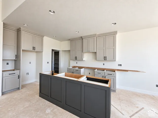 Kitchen featuring recessed lighting, a central island, light gray cabinetry, dark gray island cabinetry, and wood-finish countertop material