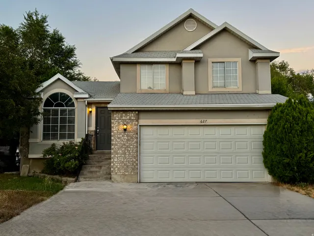 Two-story property featuring a front-facing attached garage and a concrete driveway