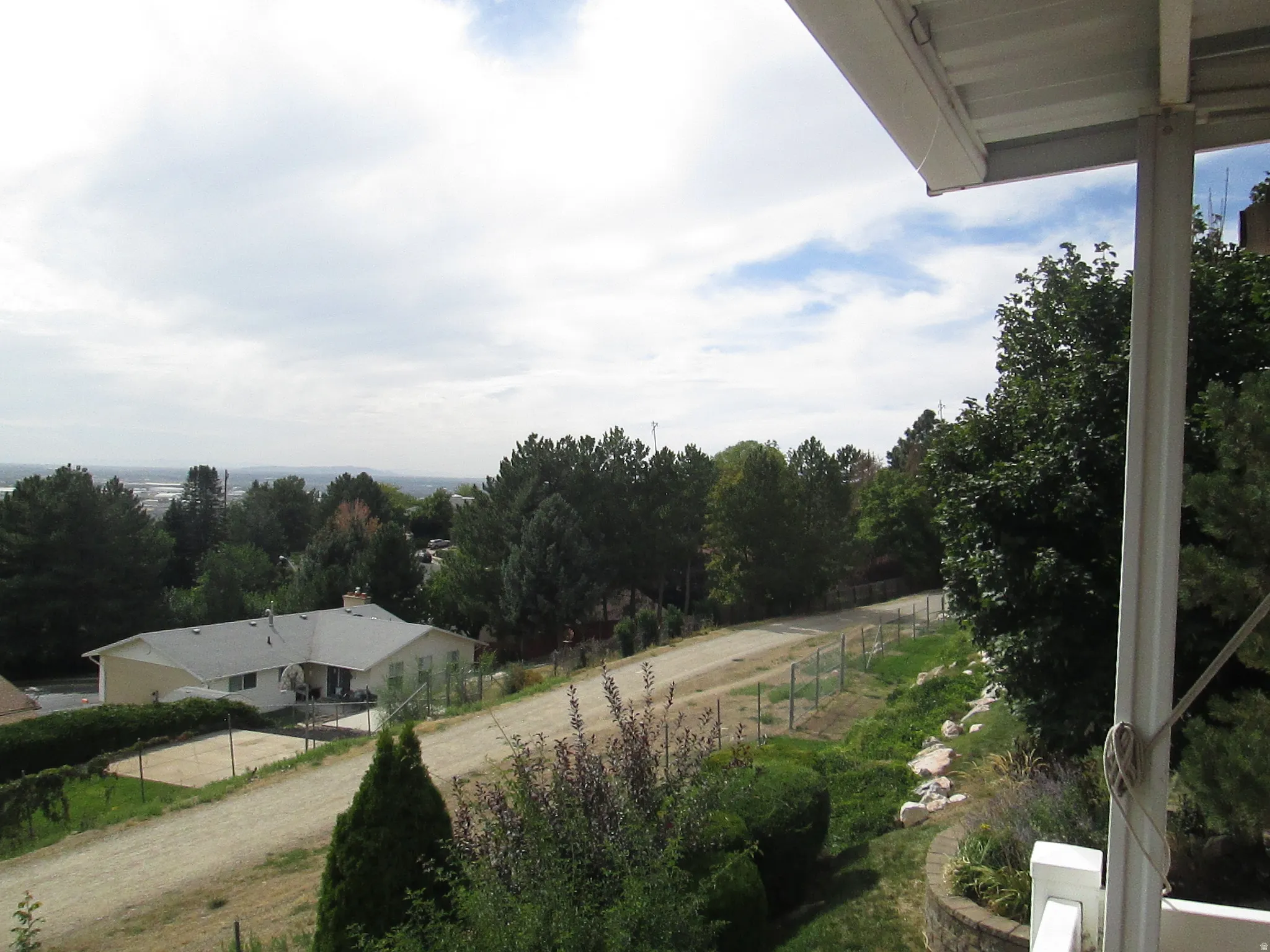 Expansive outdoor area featuring mature trees and established landscaping