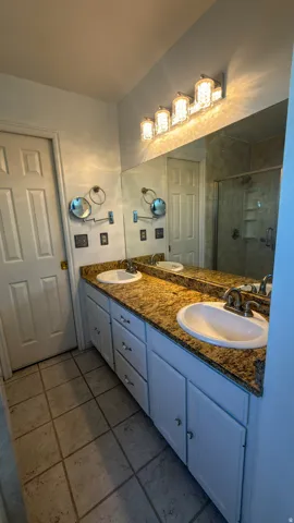 Master Bath, dual vanity featuring white cabinetry, a speckled countertop, and two integrated sinks
