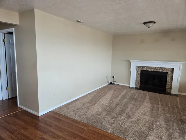 Living space featuring a fireplace with a white mantel and mosaic tile surround