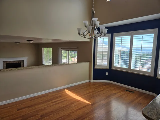 Dining area featuring wood-finish flooring and a contemporary chandelier