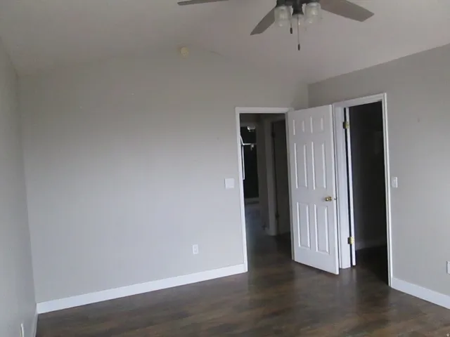 Master Bedroom, vaulted ceiling with a ceiling fan, wood-finish flooring, and white trim throughout.