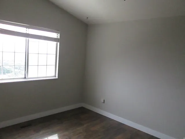 Master Bedroom window with grid inserts, wood-finish flooring, and light-toned walls